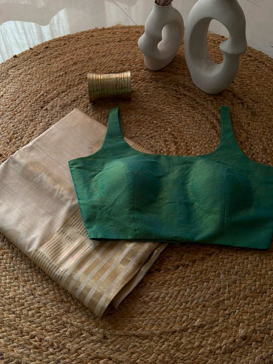Sunheri Onam saree with Green scoop neck stitched blouse.