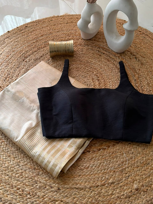 Sunheri Onam saree with Black scoop neck stitched blouse.