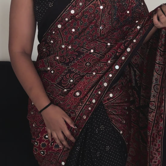Woman wearing black and maroon Durga sheesha work saree with elegant festive styling
