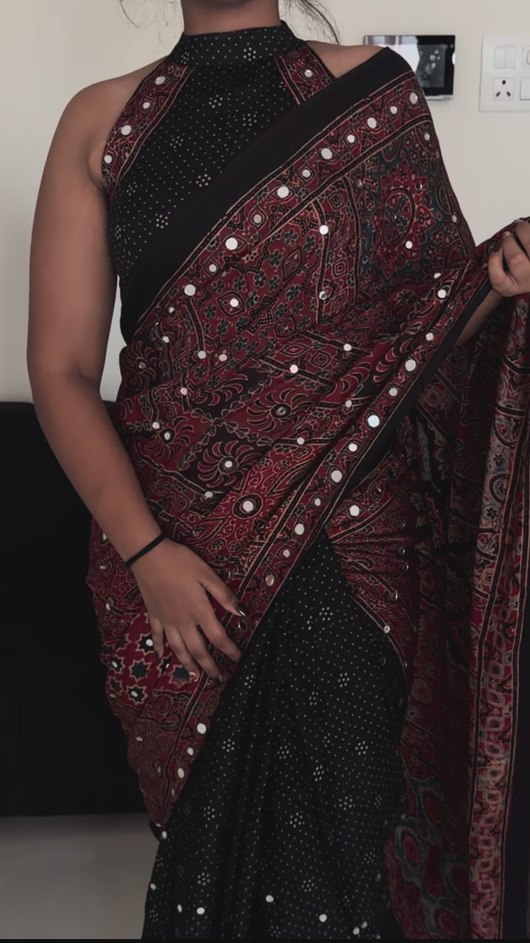 Woman wearing black and maroon Durga sheesha work saree with elegant festive styling